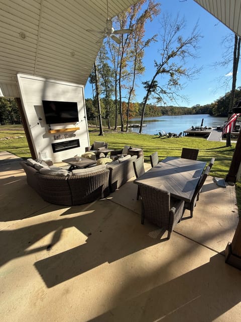 Beautiful and spacious patios with dining table, bar, couch, hot tub, and 2 TV's