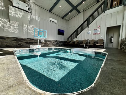 Enjoy a private indoor swimming pool with a basketball hoop, comfy seating