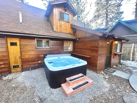 Private outdoor hot tub, surrounded by tall pines, perfect for relaxing under the trees after a day of adventure—enjoy peaceful forest views, fresh air, and a truly rejuvenating stay.