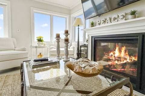 Welcome to your waterfront haven — cozy up by the fire as you take in uninterrupted views of Long Island Sound.