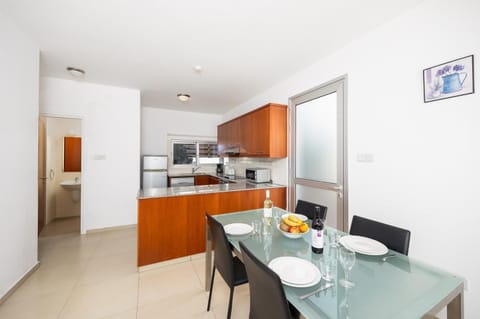 Open-plan living room with sofas, dining area, kitchen, A/C, WiFi internet, and satellite TV