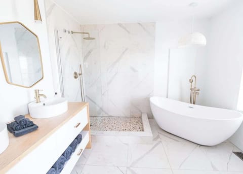 This Master Bedroom ensuite has 2 sinks, stand up shower, a modern freestanding bathtub and toilet!