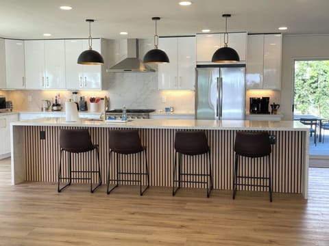 GOURMET KITCHEN with huge island, open to the family room, and the back-yard