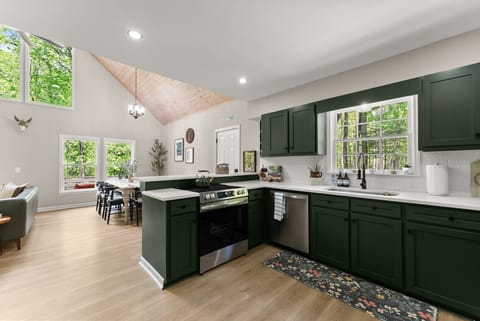This modern kitchen is equipped with sleek Frigidaire stainless steel appliances, ample counter space, and rustic bar seating. Whether you're preparing a gourmet meal or a quick snack, this kitchen has everything you need for a perfect stay