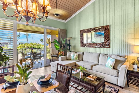 The spacious living area features a comfortable sectional sofa and a dining table.