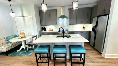 Kitchen with full sized appliances, countertop seating and cozy dining nook.