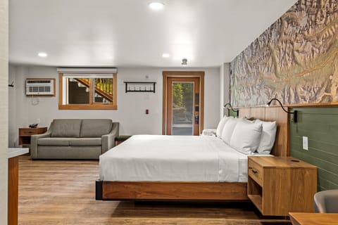 Modern and cozy room with a plush bed and additional seating area, perfect for relaxing.