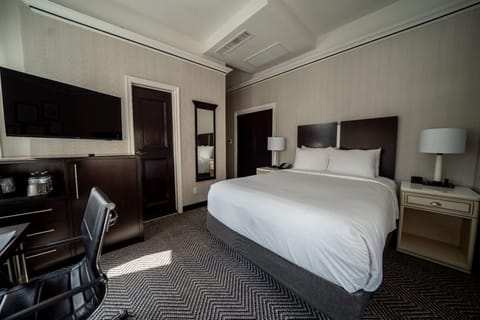 Unwind in a serene room with TV and plush bedding.