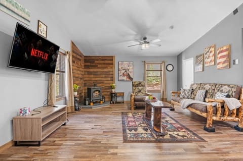 The rustic wood paneling and log-frame sofa set a cozy, nature-inspired tone, perfect for unplugging from the daily grind.