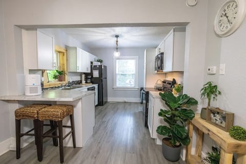 Fully stocked kitchen with cookware, coffee maker & modern appliances.