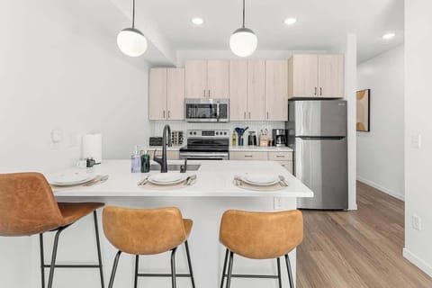 Bright, modern kitchen with stainless steel appliances, island seating, and style