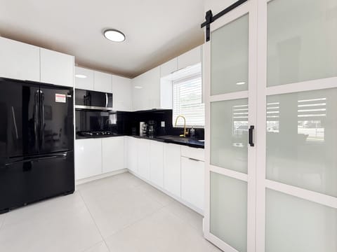 Sleek white kitchen with black accents—perfect for extended stays.