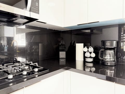 Luxury kitchen with black marble & gas stove—chef-ready for your stay.
