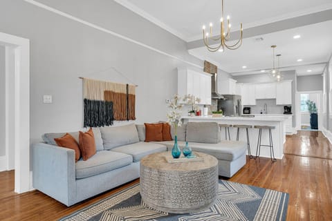 Spacious and stylish living area featuring a cozy sectional, exposed brick fireplace, and modern decor—a perfect spot to relax after exploring New Orleans.