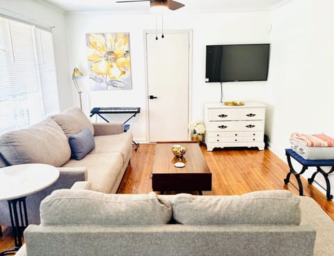 The living room with a smart tv, & a view of the front yard & private parking