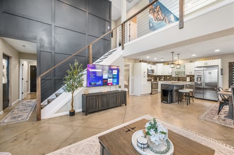 The open-concept living room makes it easy to stay connected—whether you’re cooking in the kitchen, lounging on the sectional, or gathering for a movie on the 65” smart TV.