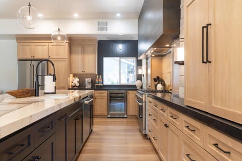 Chef's kitchen with high-end appliances, white oak cabinetry, and Patagonia quartzite marble counters