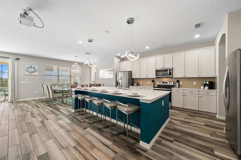 - Modern kitchen with large island and bar seating  
- Spacious Orlando villa rental with chef style design  
- Perfect for family reunions near Disney attractions