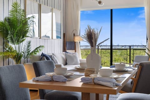A closer look at the dining setup, complete with chic, minimalist dishware and a serene view through the windows.