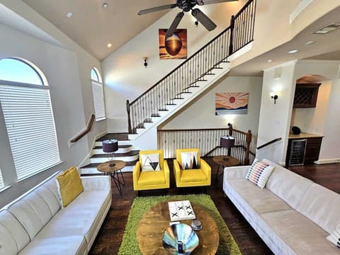 Modern living room with bright lighting and cozy white couches.