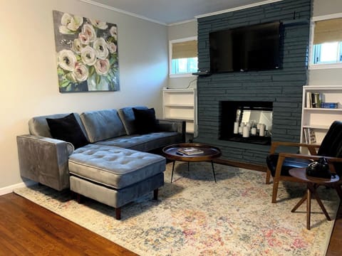 Stylish mid-century modern touches in the living room with 55" smart TV and plenty of candles in the fireplace for ambiance & relaxation.