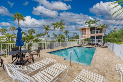 Shared Heated Pool has Sun Loungers and Dining Tables with Umbrellas