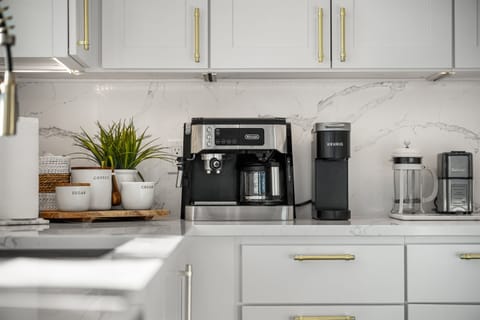 Coffee staion with espresso maker, coffee pot, Keurig, french press, grinder, Steamer, coffee beans, pods and sugar.