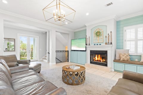 Unwind in this elegant living room where soft leather seating surrounds a crackling fireplace, creating your perfect retreat.