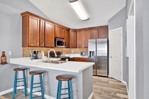 Cook with ease in this fully equipped kitchen featuring modern appliances, spacious countertops, and a cozy breakfast bar with seating