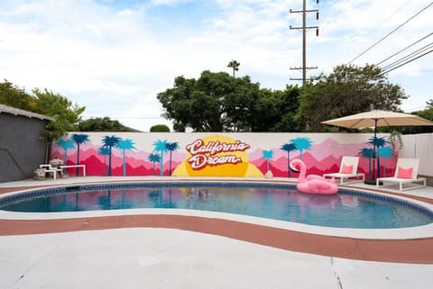 Welcome to your California Dream! 🌴☀️ Our backyard pool area is a vibrant oasis, complete with a colorful mural, lush greenery, and plenty of space to unwind and soak up the sun. Perfect for creating unforgettable memories