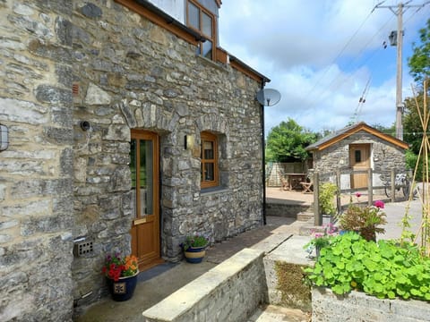 The outside of Meadow View Cottage with flowers and plants