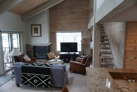 Living room with vaulted ceiling and stairs to upper level