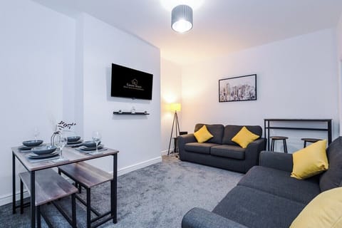 Spacious living room with a cozy sofa and large TV for relaxing nights.