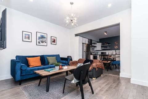 Bright and spacious white living area with a bold blue sofa, adding a pop of color to this inviting and modern space.