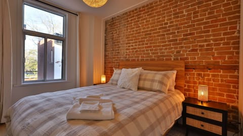 Bright bedroom with exposed brick and a cozy atmosphere