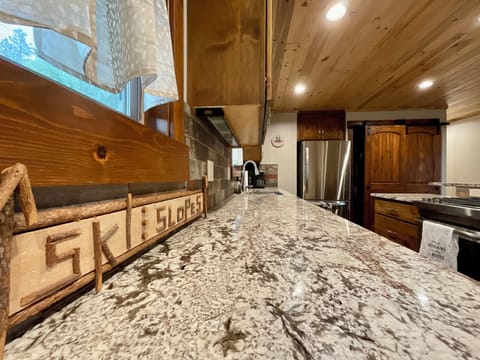 Spacious kitchen featuring gas stove, dishwasher and refrigerator.