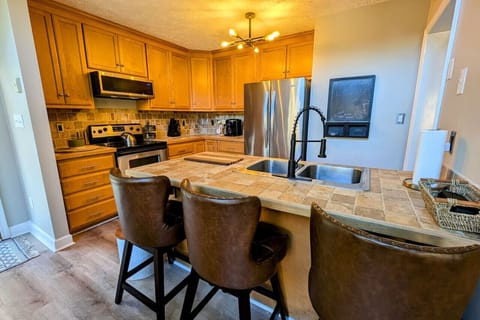 Fully stocked kitchen including crock pot, Keurig and coffee pot stocked with coffee pods, sugar, and creamer