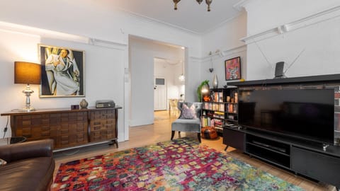 Character filled living room with rich textures, leather seating and a vibrant feature rug