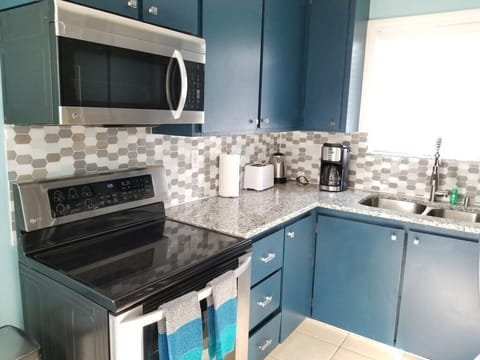 Bright kitchen with modern appliances and stylish blue cabinets.