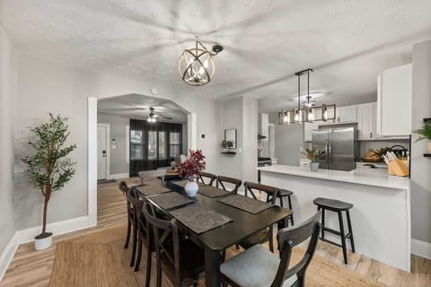Enjoy meals and conversations at this spacious 8-person dining table, overlooking a gourmet kitchen and sleek bar counter.