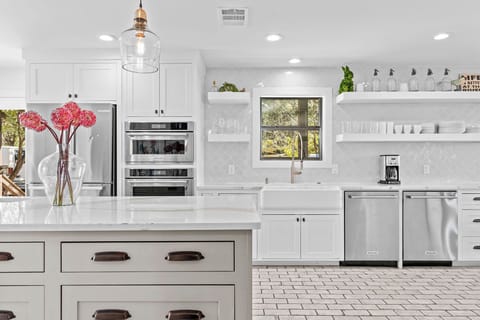 The kitchen is equipped with top-of-the-line appliances, including a double oven for effortless meal preparation, an ice maker to keep drinks chilled, and double dishwashers for easy cleanup after entertaining. Perfectly designed for hosting gatherings wit