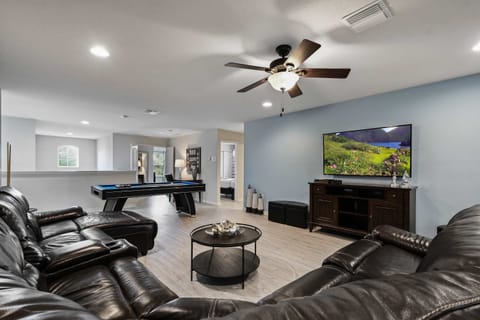 Game room with pool table, cozy seating, and large TV for ultimate relaxation.