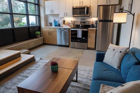 Living room with sofa, coffee table, and kitchen view