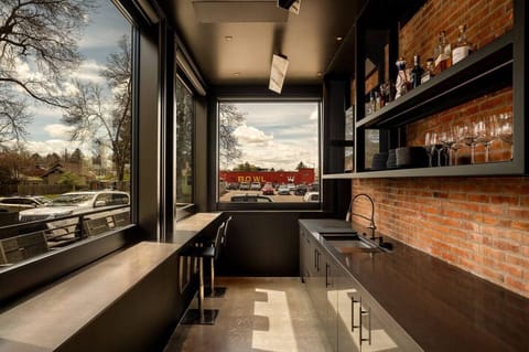 RH | Our sleek bar area features expansive windows that frame the stunning outdoor views. Perfect for enjoying a glass of wine or a cocktail.