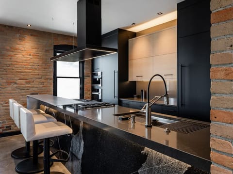 RH | Savor culinary excellence in our luxury vacation rental’s modern kitchen, equipped with top-of-the-line appliances and a sleek design that combines functionality with sophisticated style.