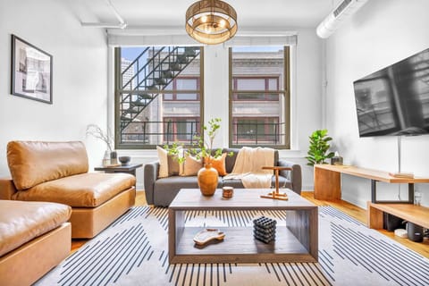 The property showcases a warm living room with a large window that allows natural light to brighten the space, ideal for a cozy stay experience.