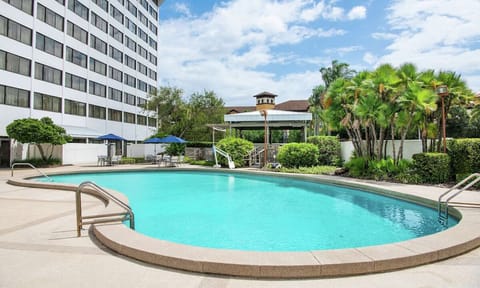 Dive into a sparkling outdoor pool beside the hotel tower.