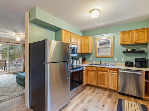 Fully equipped kitchen featuring wood cabinets and stainless steel refrigerator.