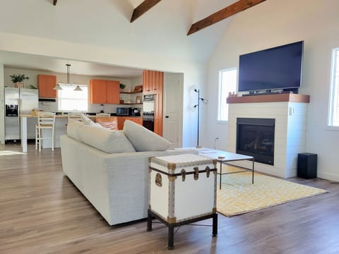Living room with gas fireplace and comfy seating. Right off of the kitchen to maximize family time - whether you're cooking, watching the big game, or relaxing by the fire!