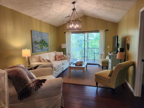Living Area with vaulted ceilings and sliding glass door to screened in porch